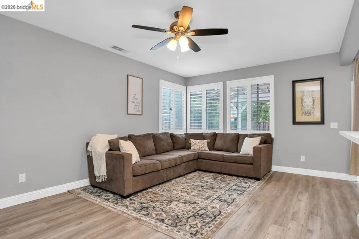 Living room with light wood-style floors and a ceiling fan