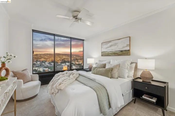 Bedroom featuring light colored carpet, crown molding, and a ceiling fan