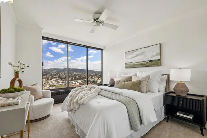 Bedroom with ornamental molding, light colored carpet, a ceiling fan, radiator, and a mountain view