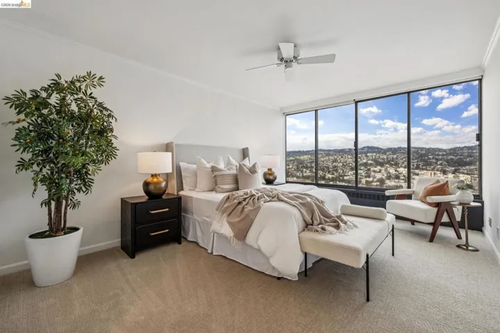 Bedroom with crown molding, light carpet, floor to ceiling windows, ceiling fan, and a mountain view