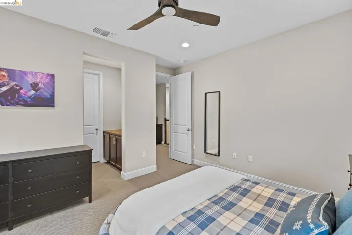 Bedroom with light carpet, a ceiling fan, connected bathroom, and recessed lighting