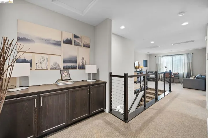 Hall featuring an upstairs landing, light colored carpet, and recessed lighting