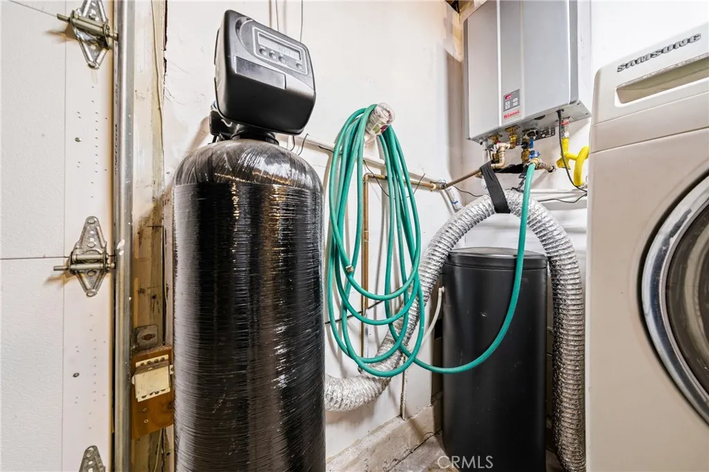 Garage view featuring water softener utility upgrade and a tankless water heater.