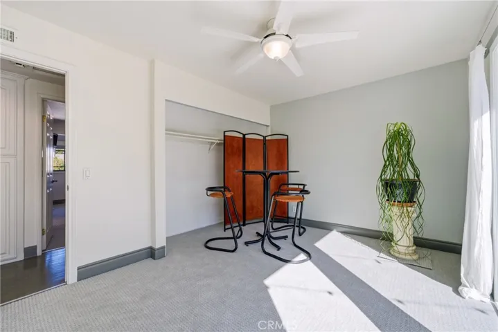 Secondary bedroom with new carpet, ceiling fan, and a clean neutral palette.
