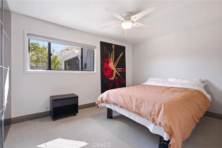 Updated secondary room with ceiling fan and fresh baseboards.