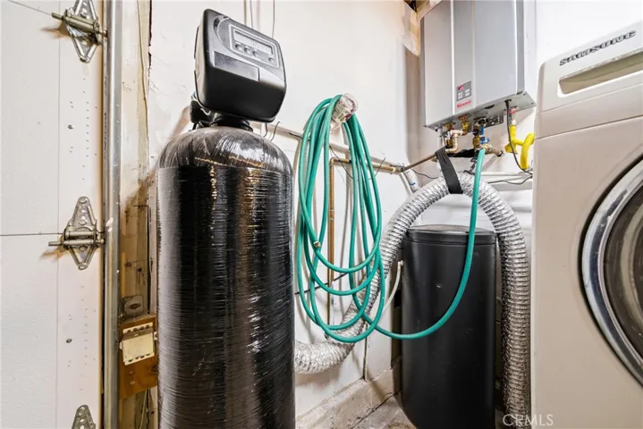 Garage view featuring water softener utility upgrade and a tankless water heater.