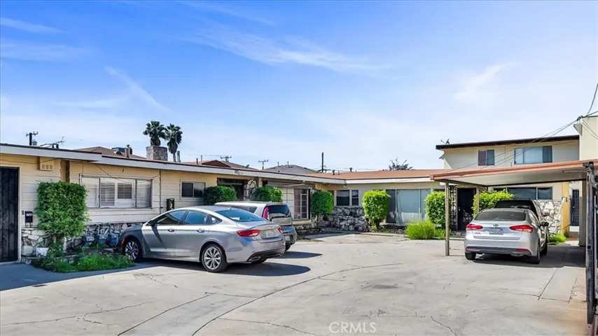 L-Shaped building shows last unit on the end as 9710 Alondra Blvd. 1/1  Carport Parking Space for Units with Metal rolling gate that separates Home from Commercial Building