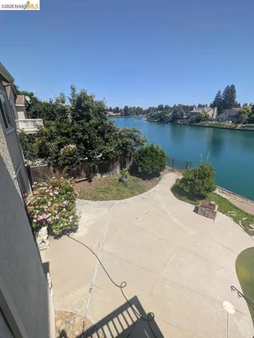 fenced backyard with a water view and a patio