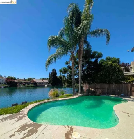 outdoor pool with a fenced backyard and a patio