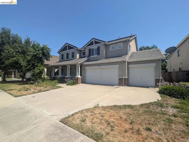 craftsman house featuring brick siding, driveway, stucco siding, and a garage