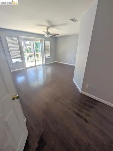 empty room featuring dark wood-type flooring and a ceiling fan