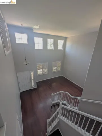 stairway with wood finished floors, healthy amount of natural light, and a high ceiling