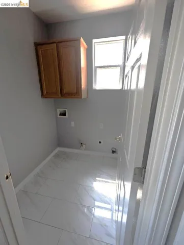 laundry room with hookup for a washing machine, cabinet space, light marble finish floors, gas dryer hookup, and hookup for an electric dryer
