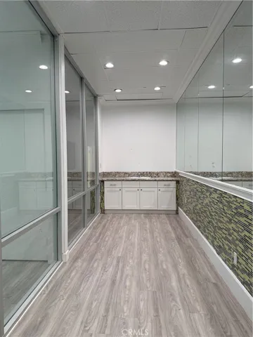 Glass and mirrored walls with a vanity cabinet.