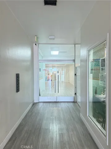 Building hallway looking towards the double glass entry of the unit.