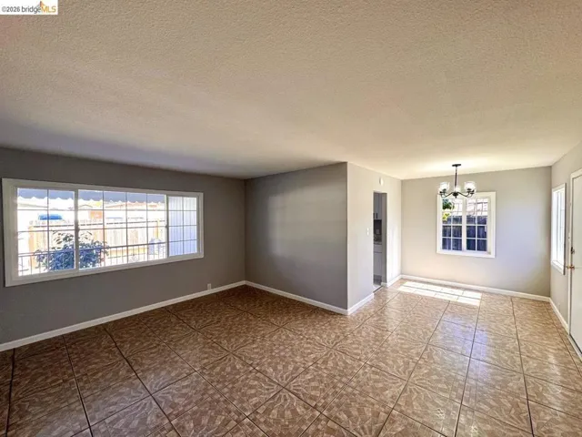 Unfurnished room with a chandelier and a textured ceiling