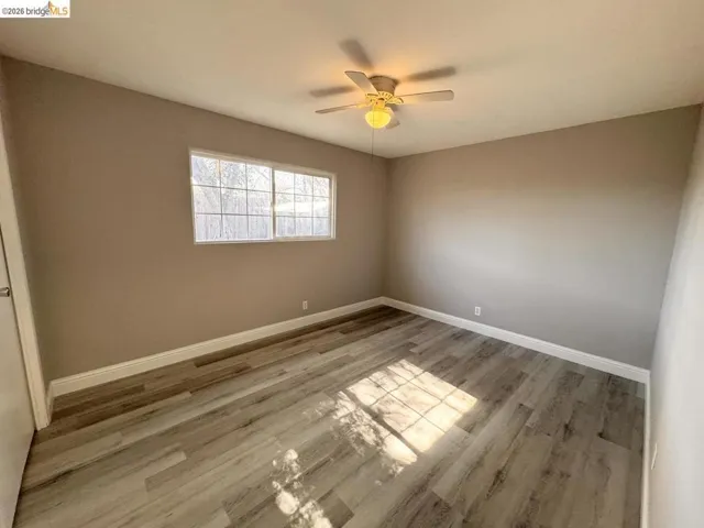 Spare room featuring light wood-style floors and ceiling fan