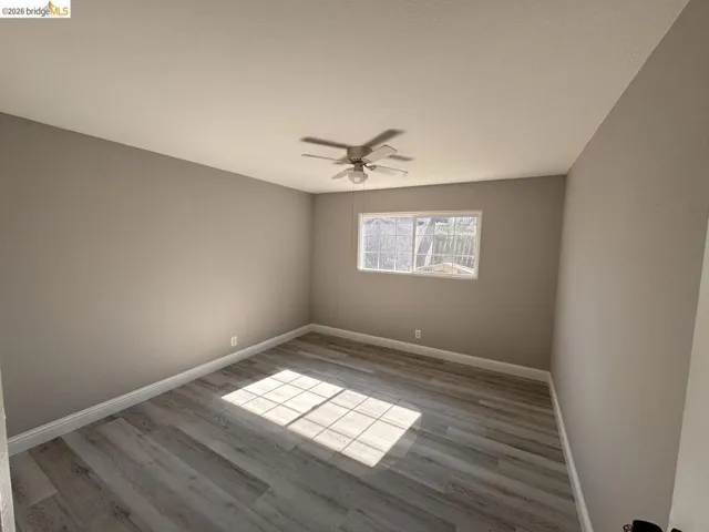 Spare room with light wood-type flooring and ceiling fan