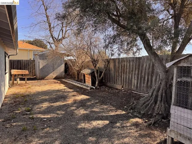 Fenced backyard featuring a shed