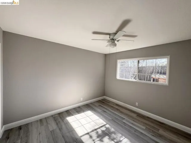 Spare room featuring ceiling fan and light wood-style flooring