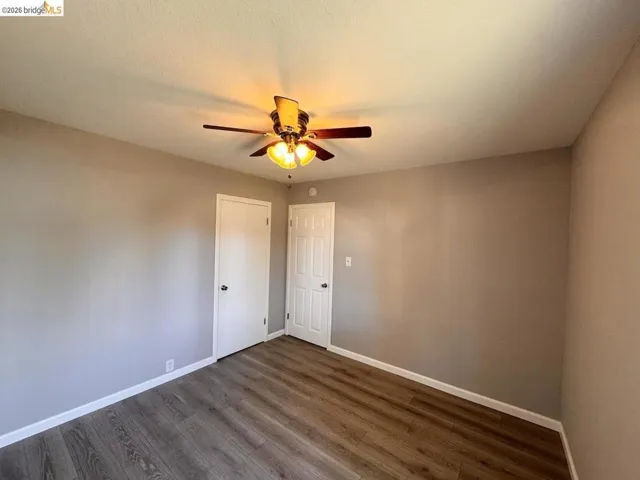 Spare room featuring a ceiling fan and dark wood finished floors