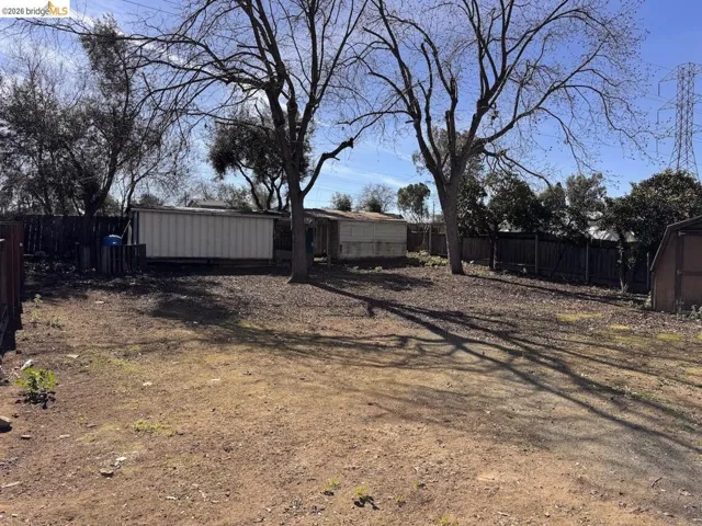 Fenced yard featuring a storage shed