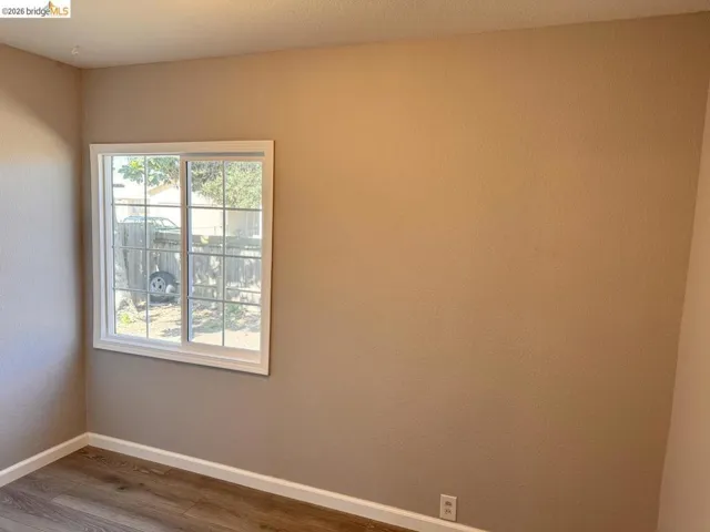 Unfurnished room featuring baseboards and wood finished floors