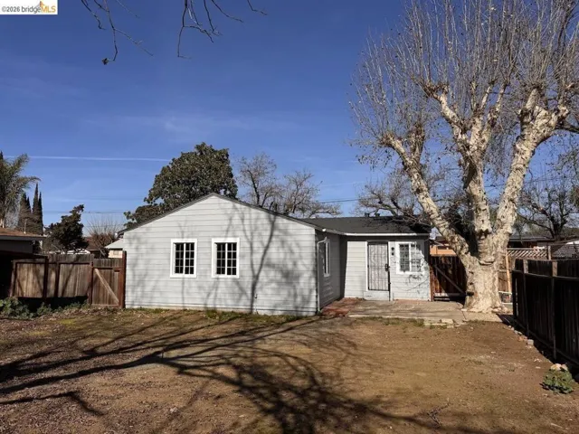 Back of house featuring a gate, a fenced backyard, and a patio area