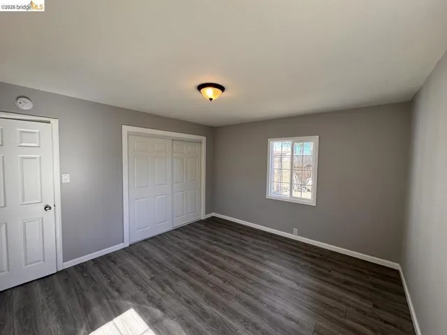 Unfurnished bedroom with dark wood finished floors and a closet