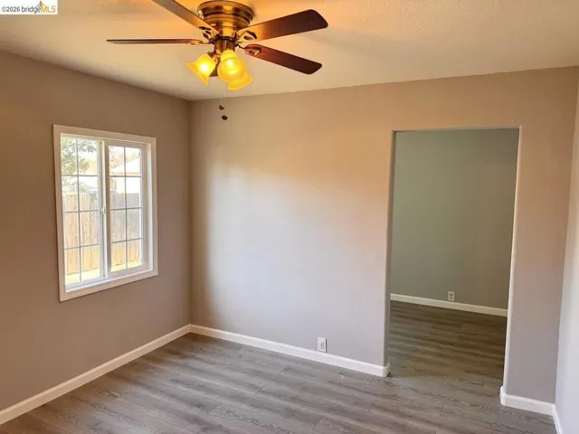 Unfurnished room with light wood finished floors and ceiling fan
