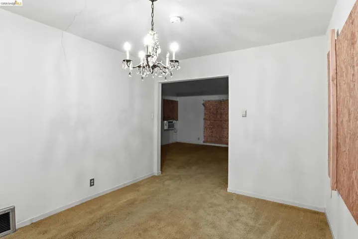 Unfurnished dining area featuring a chandelier and carpet flooring