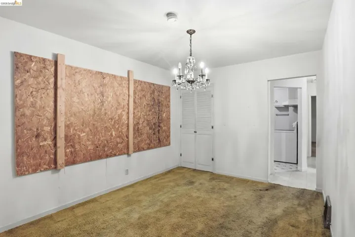 Unfurnished dining area with a chandelier and carpet