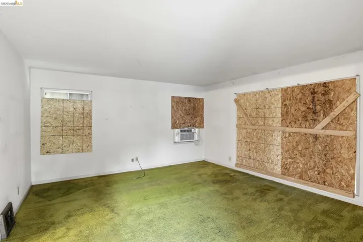 Carpeted empty room featuring cooling unit