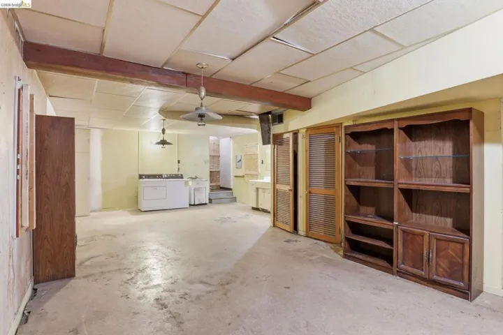 Finished basement area featuring a paneled ceiling and washer and clothes dryer.