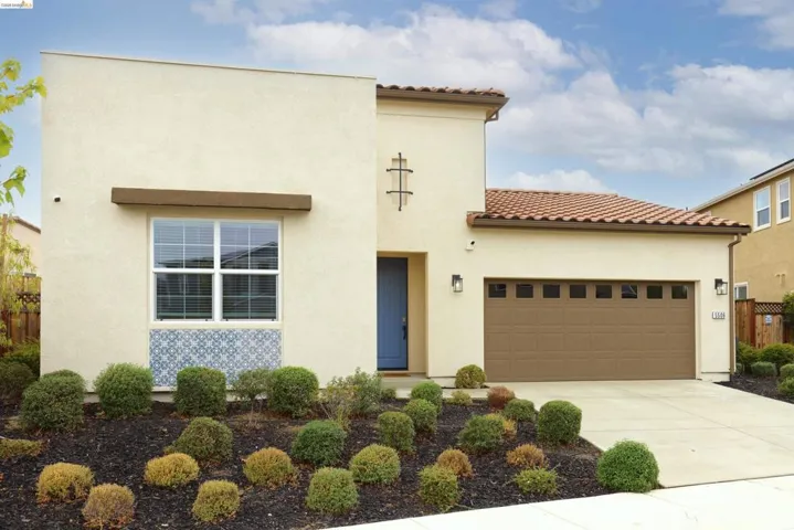 Mediterranean / spanish home with a tile roof, stucco siding, concrete driveway, and a garage