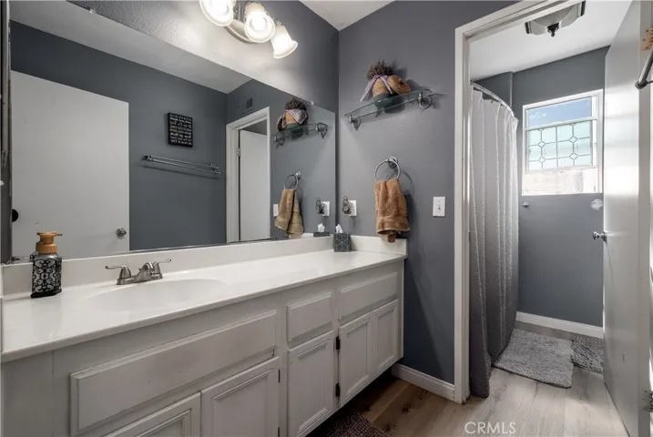Upstairs guest bathroom with shower/tub combo and waterproof plank floors.