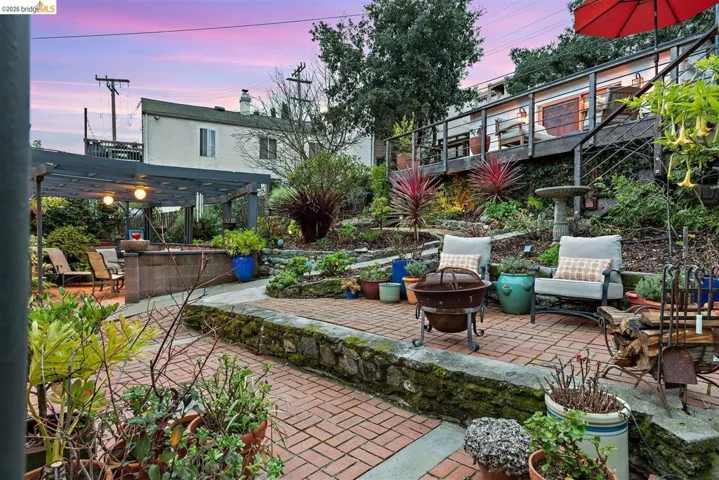 Patio terrace at dusk with an outdoor fire pit, a patio, and a pergola