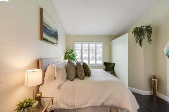 Bedroom with dark wood-style floors and baseboards