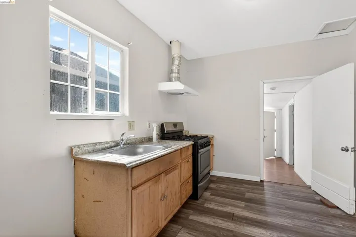 Compact kitchen featuring wood-finish flooring and light-toned walls