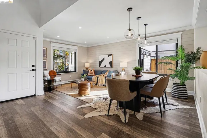Dining space with wood walls, dark wood finished floors, recessed lighting, and ornamental molding