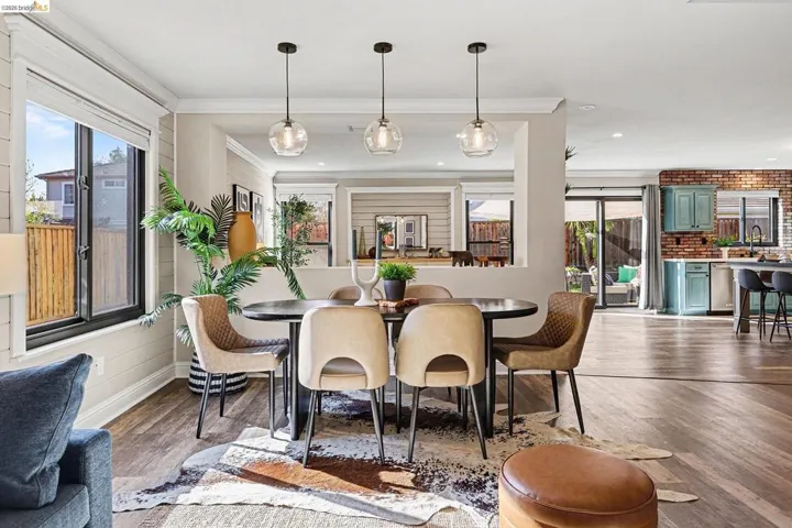 Dining space with dark wood-style floors and ornamental molding