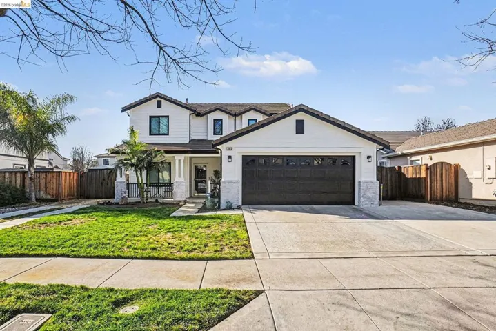 Modern farmhouse featuring covered porch, concrete driveway, and an attached garage