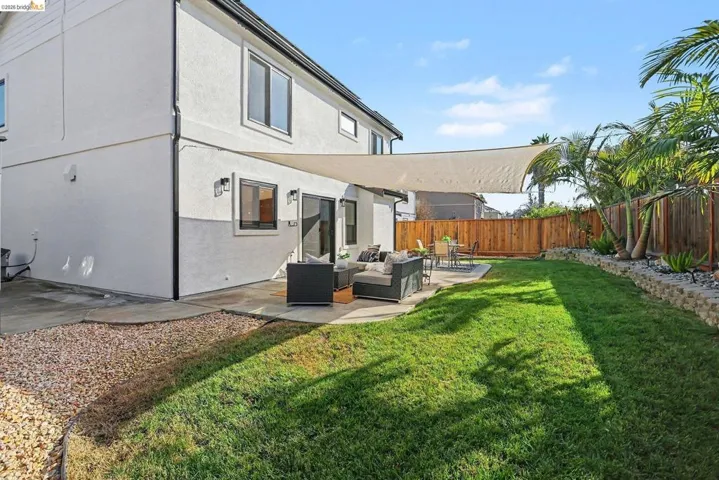 Rear view of property with outdoor furniture, a patio area, a fenced backyard, and stucco siding