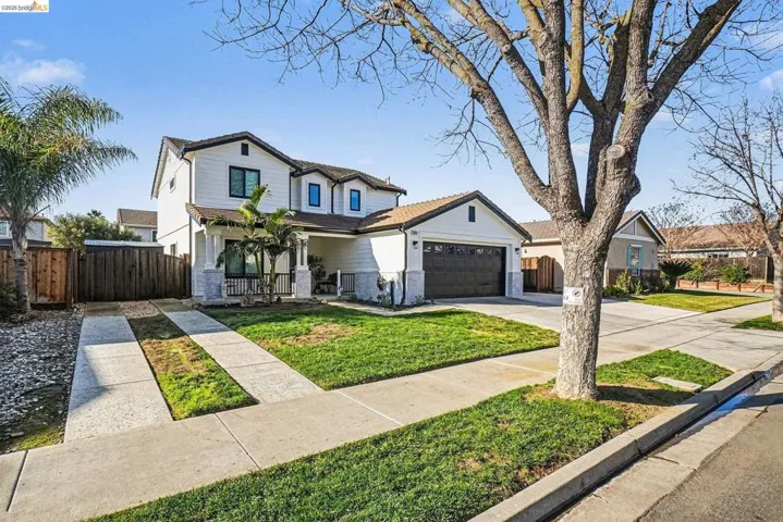 Traditional-style home featuring driveway, an attached garage, and brick siding