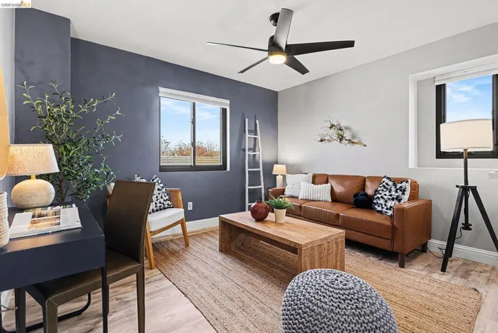 Living room with light wood finished floors and ceiling fan