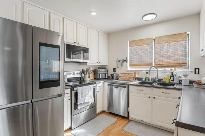 Stainless steel appliances: electric range, microwave, and dishwasher.