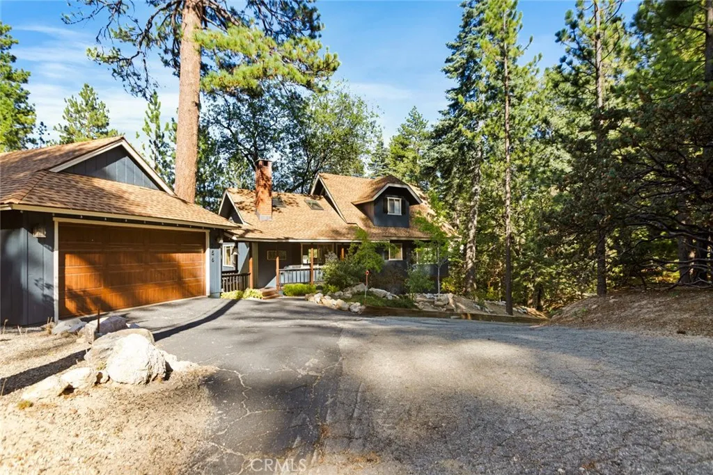 The cabin features a level entry, a detached two-car garage with a covered walkway to the house, and easy year-round access from two main roads.