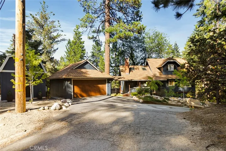 The cabin features a level entry, a detached two-car garage with a covered walkway to the house, and easy year-round access from two main roads.
