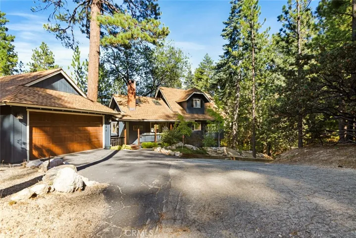 The cabin features a level entry, a detached two-car garage with a covered walkway to the house, and easy year-round access from two main roads.