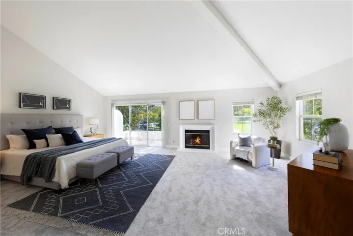 Primary bedroom featuring cathedral ceilings, lounge space, and private balcony overlooking park / greenbelt.